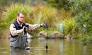 Person standing in water with measuring equipment.